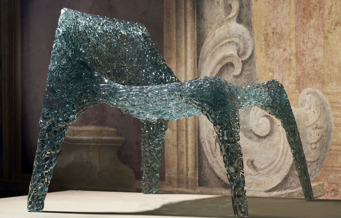 A contemporary lounge chair featuring a unique translucent, textured surface that evokes the appearance of crushed ice or sculpted glass. The chair exhibits a wide, gently reclined seat and backrest, supported by four robust, molded legs, all formed from a single continuous piece of material. — 3D model