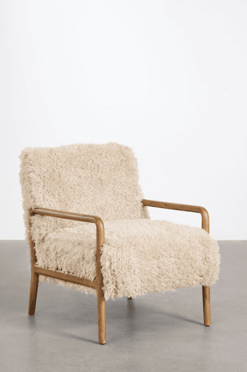 A cream-colored armchair with a textured, fluffy upholstery. The frame and armrests are made of polished wood, featuring a minimalist design with gently curved lines. The chair rests on four wooden legs. — 3D model