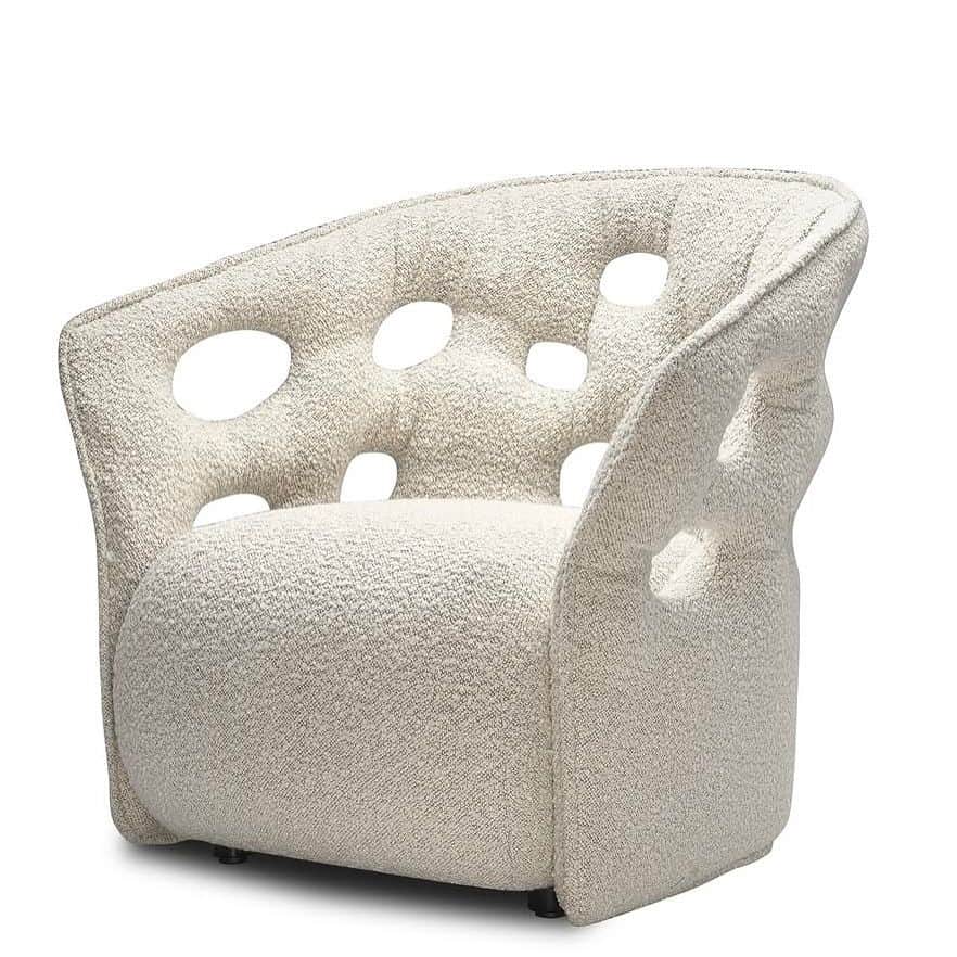 A cream-colored armchair with a curved back and seat. The upholstery features a textured boucle fabr… — 3D model