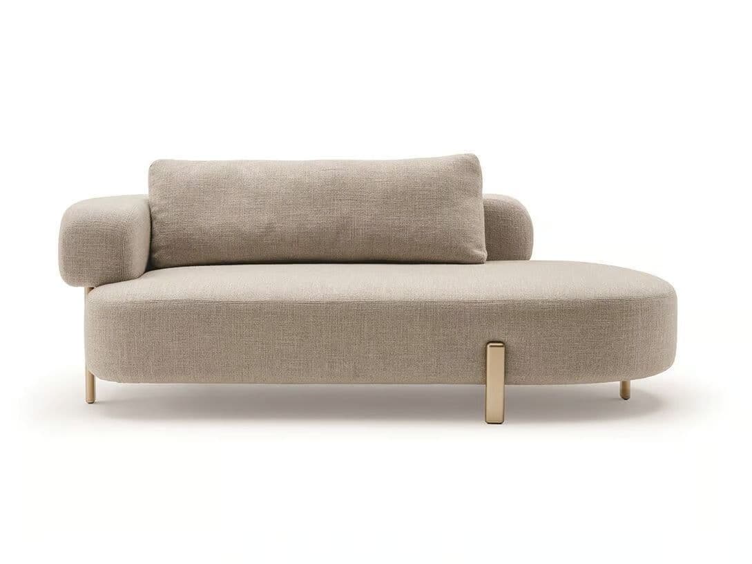 A modern chaise lounge with a curved, upholstered body and a single rounded armrest. It features a rectangular accent cushion placed horizontally on the seat. The piece is supported by slender, metallic legs, with one prominent, upright metal support visible on the side. — 3D model
