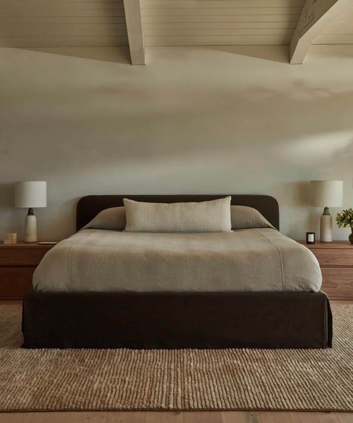 A modern upholstered bed featuring a low-profile platform base and a gently curved headboard, all co… — 3D model