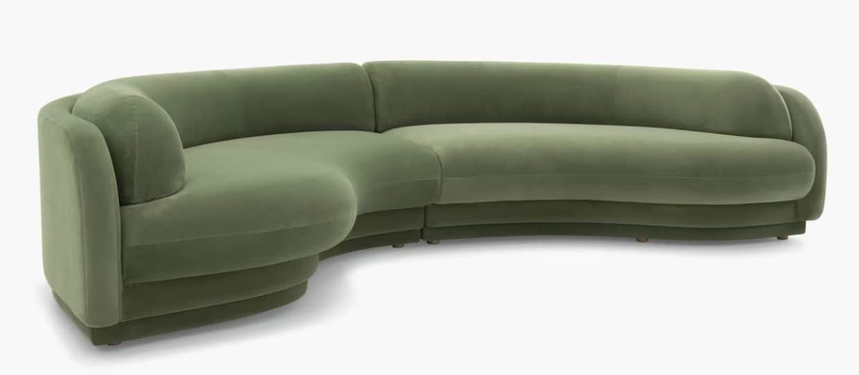 A modular, curved sectional sofa upholstered in a soft, green velvet-like fabric. The sofa features… — 3D model