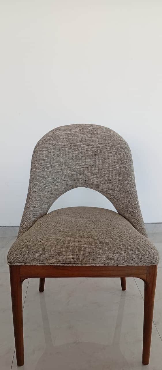 A contemporary dining chair featuring a light gray upholstered seat and a distinctive curved backres… — 3D model