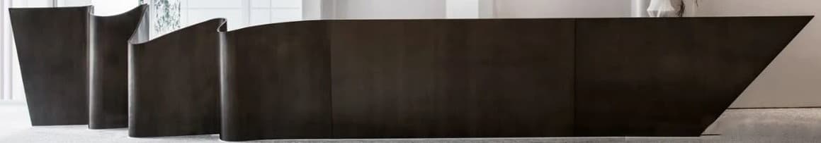 An elongated, low-profile credenza featuring a distinctive undulating or wavy front facade. The piece has a dark, possibly wooden or laminate, finish and appears to be designed for modern interiors, likely as a wall-mounted unit or with a recessed base to give a floating appearance. It contains multiple hidden storage compartments. — 3D model
