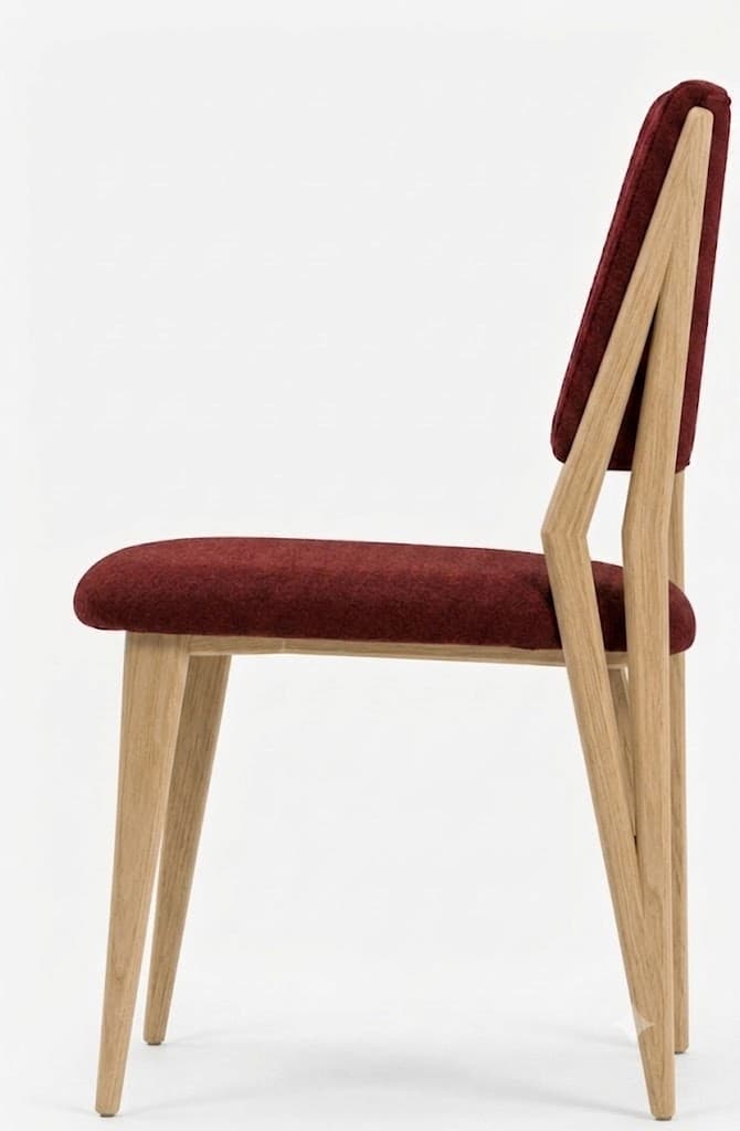 A contemporary dining chair featuring a light-toned wooden frame and deep red fabric upholstery. The design is characterized by its angular rear legs that extend upwards to form the backrest support, and its clean, tapered front legs. Both the seat and backrest are padded and upholstered. — 3D model