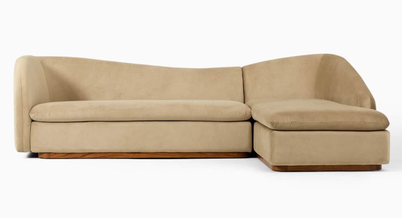 A contemporary curved sectional sofa upholstered in a light beige, plush fabric, featuring an integr… — 3D model