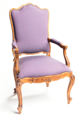 An ornate armchair with a carved wooden frame and upholstered seat and backrest. The armchair features cabriole legs and scrolled armrests. The upholstery has a repeating diamond pattern. — 3D model