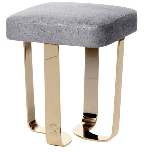 A small, upholstered stool with a square seat and four curved metal legs. The upholstery is a light grey with a textured finish. The legs are made of polished gold-toned metal and have a subtle embossed lion's head logo near the base of each leg. The design appears modern and somewhat luxurious. — 3D model