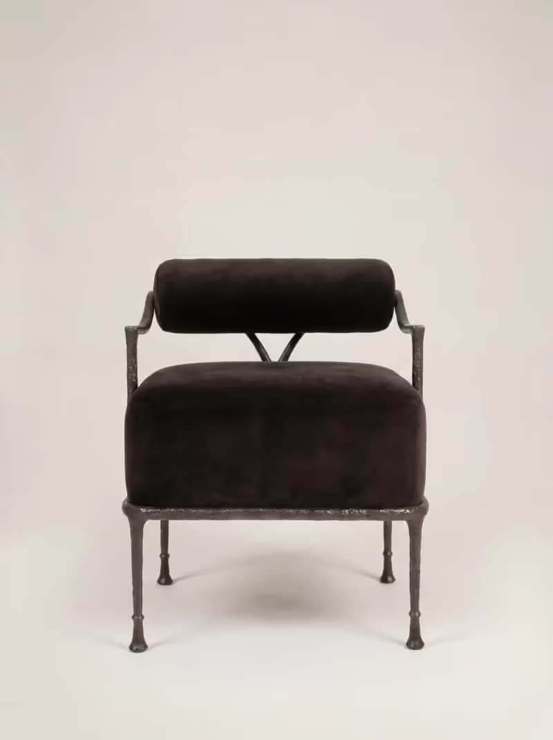 A robust armchair featuring a dark, possibly black or very dark brown, velvet upholstered seat and a… — 3D model
