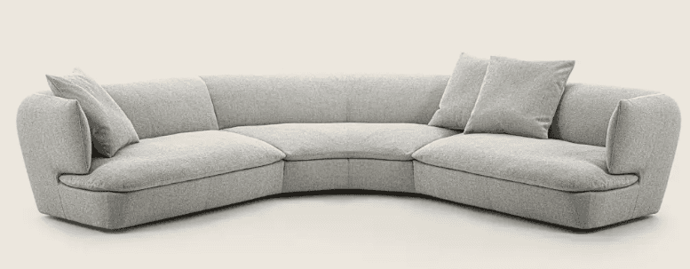 A curved sectional sofa upholstered in a light grey textured fabric. It features a low profile with… — 3D model