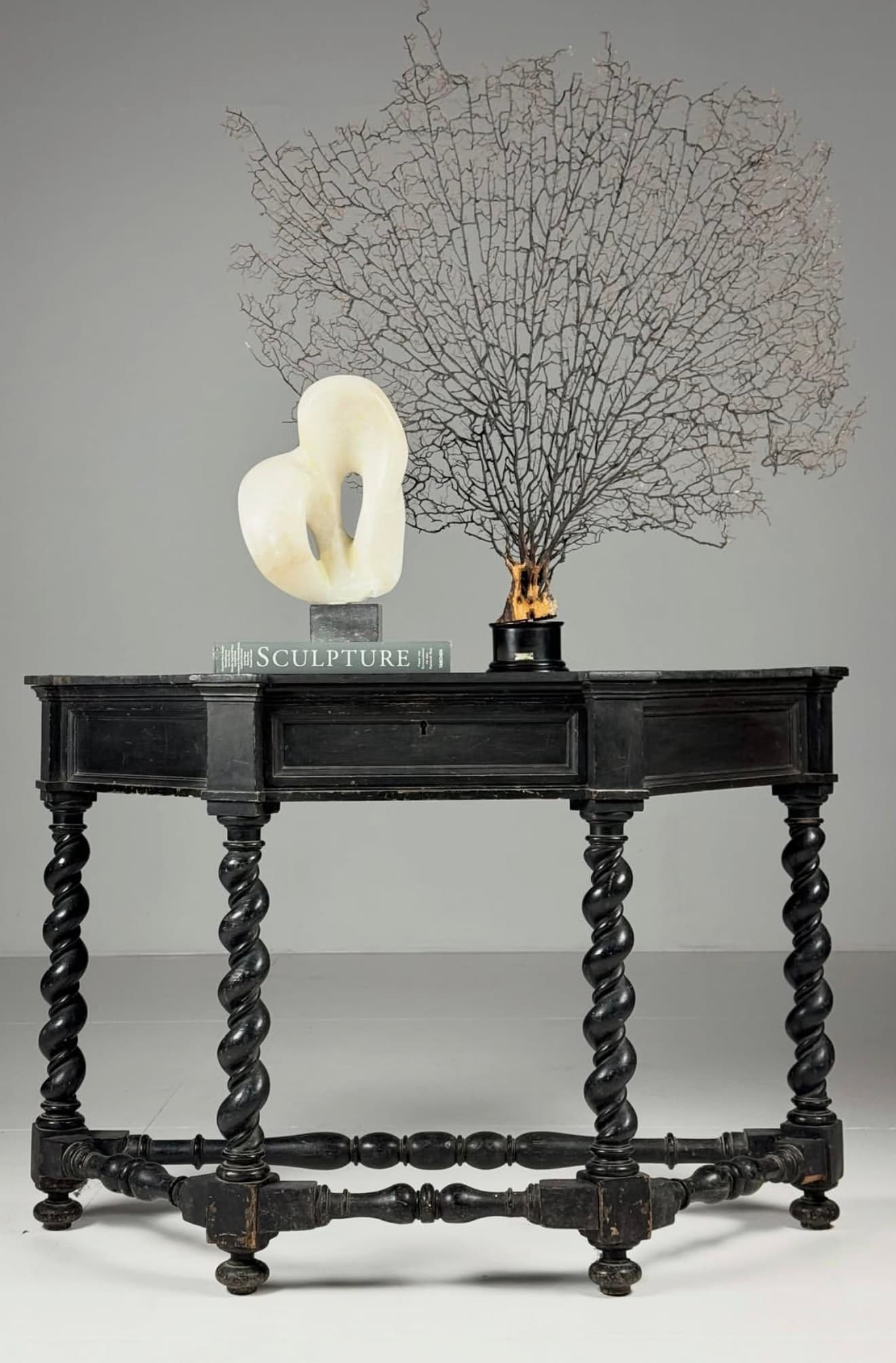 A dark-finished rectangular console table featuring distinctive barley twist legs and a single drawer with a keyhole. A twisted stretcher bar connects the lower sections of the legs, enhancing its classic design. — 3D model