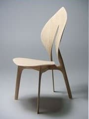 A modern, sculptural chair made from light-toned bent plywood, featuring an organically curved backrest with a central vertical slit, and a subtly shaped seat supported by four tapered legs. — 3D model