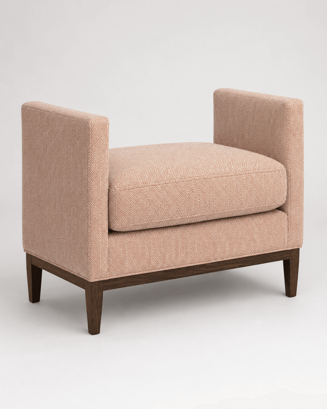 An upholstered bench featuring a contemporary design with low, squared arms and a sturdy wooden base. The fabric has a subtle herringbone pattern in a peach hue, and it sits on dark wooden tapered legs. — 3D model