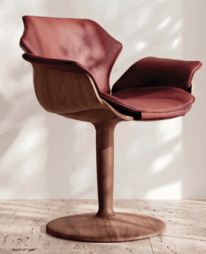 A contemporary armchair featuring a molded wooden base and stem supporting a U-shaped seat and backrest upholstered in leather. The design is characterized by its organic, flowing lines and the combination of natural wood and supple leather. — 3D model