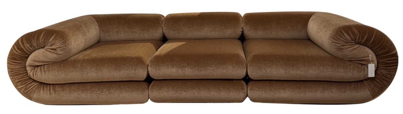A modular sofa with a distinctive rounded armrest on the left side and a bolster-style armrest on the right. The sofa features multiple seat cushions and back cushions, arranged in a linear configuration. The overall design is plush and volumetric. — 3D model