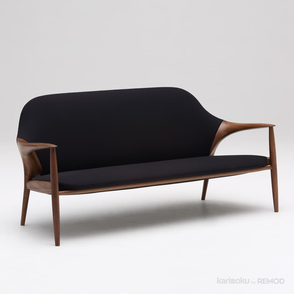 A mid-century modern inspired two-seater sofa featuring a sculpted wooden frame and a upholstered seat and backrest. The frame has elegantly curved arms that extend from the back legs and flow forward. The seat and back cushions are a solid black fabric. — 3D model