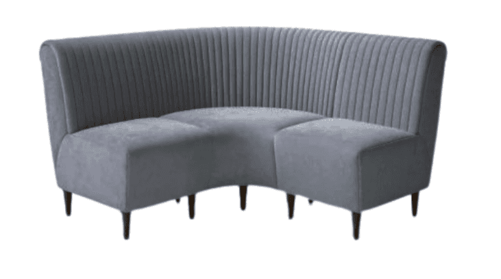 A curved, upholstered sectional sofa with a fluted backrest and a padded seat. The sofa is supported… — free GLTF 3D model