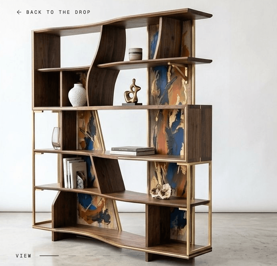 A tall, contemporary bookshelf featuring an asymmetrical design crafted from dark walnut wood with polished brass accents. The unit comprises multiple open shelves, some straight and others with graceful curves, creating varied compartment shapes. Several sections are backed with vibrant abstract art panels in blue, orange, black, and gold, bordered by the brass frame. The base mirrors the curved elements of the upper structure, providing stability and aesthetic continuity. The bookshelf is designed for both storage and artistic display. — 3D model