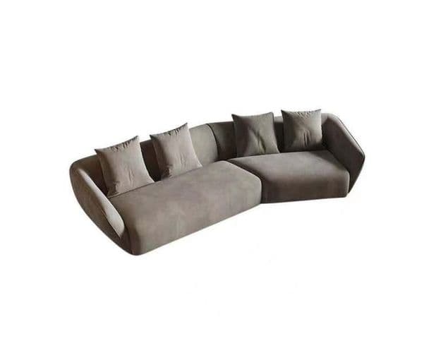 A modern, sectional sofa with a curved silhouette. The sofa features a low profile, plush cushions, and several scatter cushions for added comfort. The design appears minimalist with clean lines and a rounded armrest on the left side. — 3D model